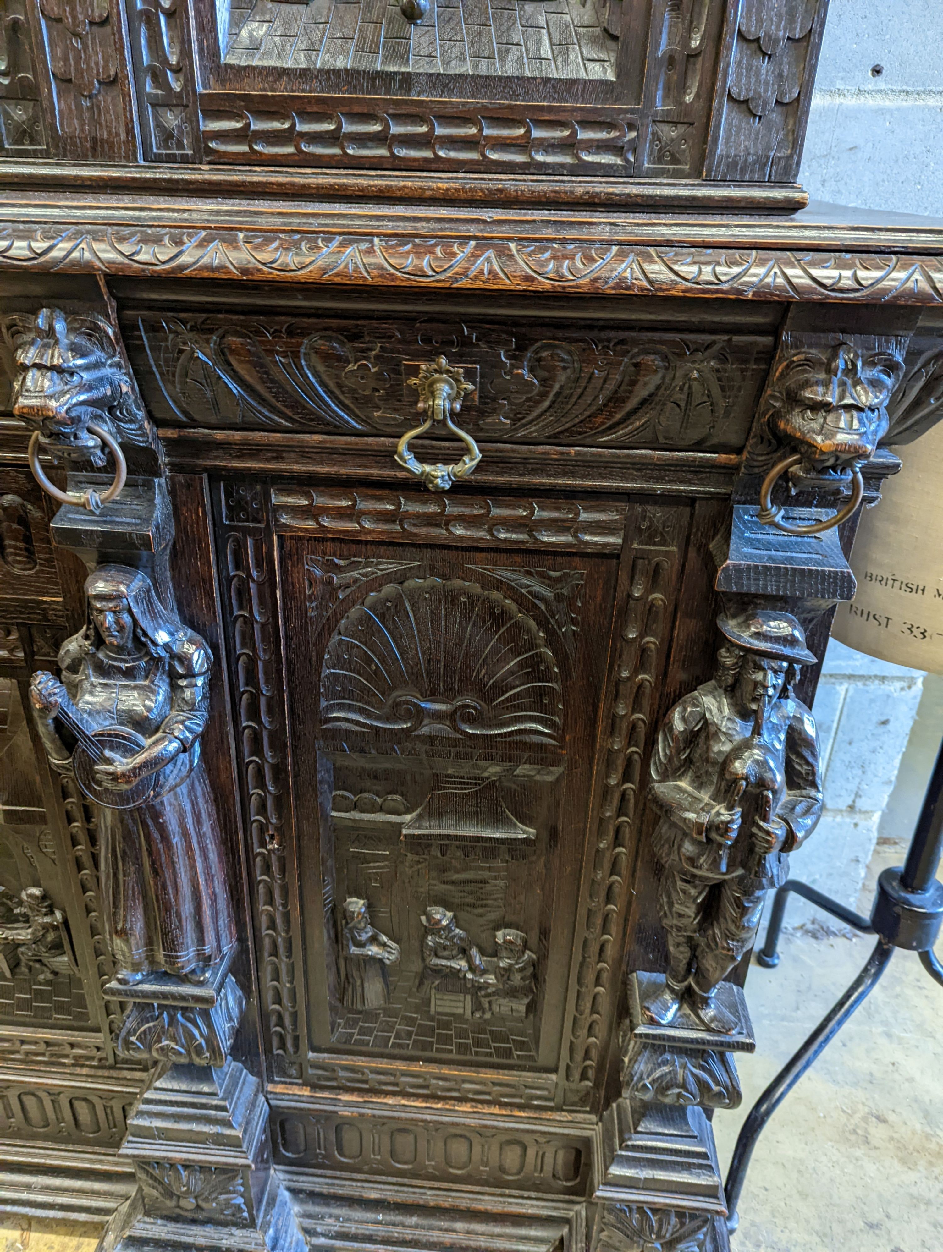 An early 20th century carved oak court cupboard in the Flemish style, length 200cm, depth 58cm, height 212cm